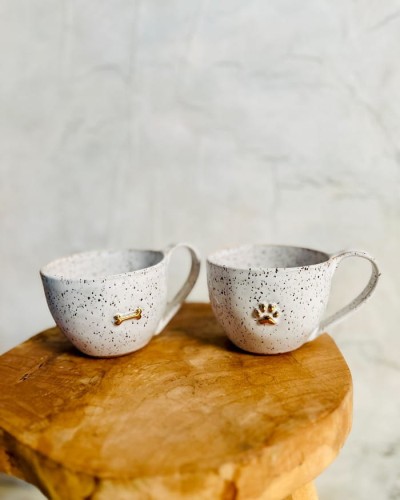 Filiżanka ceramiczna 300 ml stracciatella ze złotą łapką i złotą kostką stojąca na stole